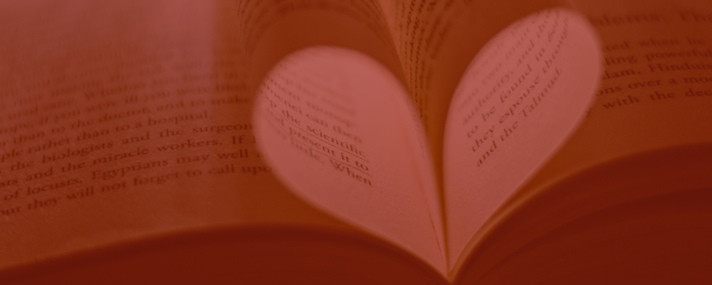 An open book with two pages turned in toward one another to form a heart; image tinted red