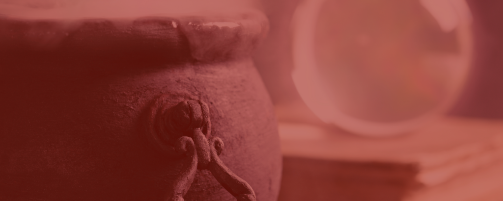 A boiling cauldron sits next to stack of books with a bauble on it; image tinted red